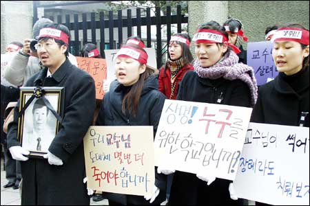 지난 12월18일 교육인적자원부 앞에서 상명대 이흥연 교수 사망 진상규명위원회 회원들이 시위를 벌이고 있다. 이흥연 교수의 아들인 이정혁 교수(왼쪽)가 영정을 든 채 재학생과 함께 성명을 낭독하고 있다. 